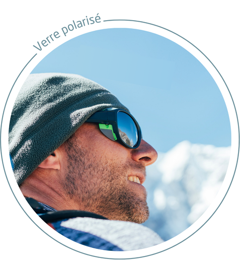 homme qui porte un bonne gris et des lunettes de sport avec des verres optiques polarisés en montagne